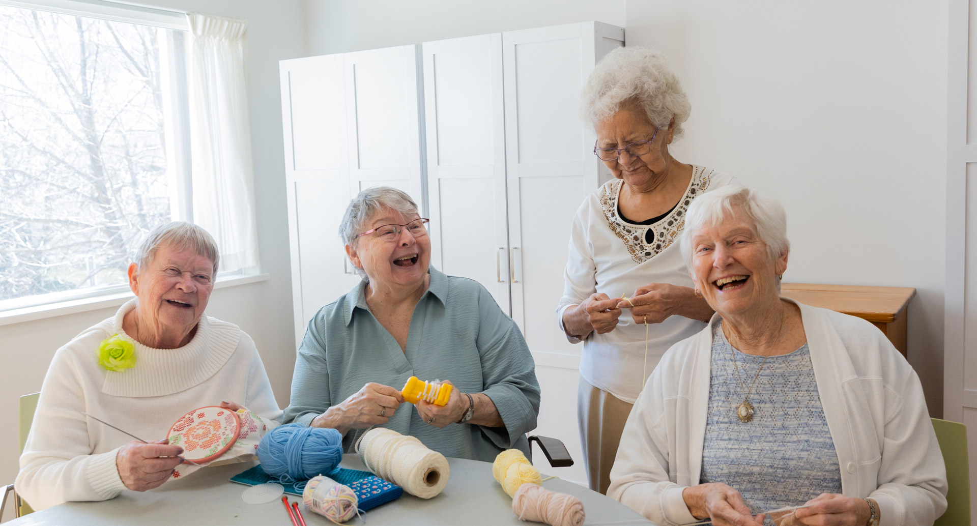 four ladies knitting and laughing